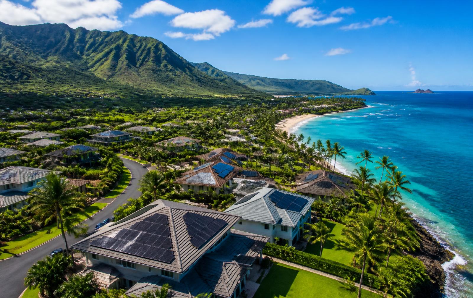 Hawaii coastline with homes, mountains and sunshine